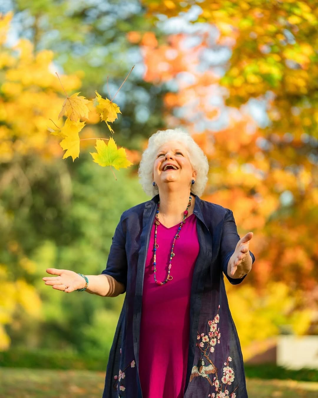 Colleen Bourassa tossing autumn leaves